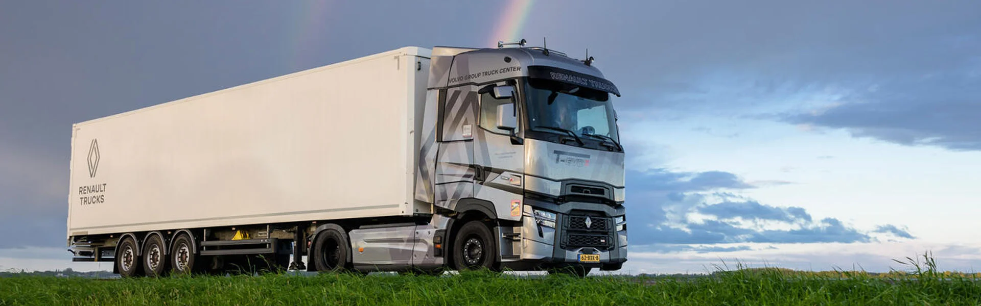Camion Renault Trucks avec semi-remorque sur la route avec arc en ciel derrière