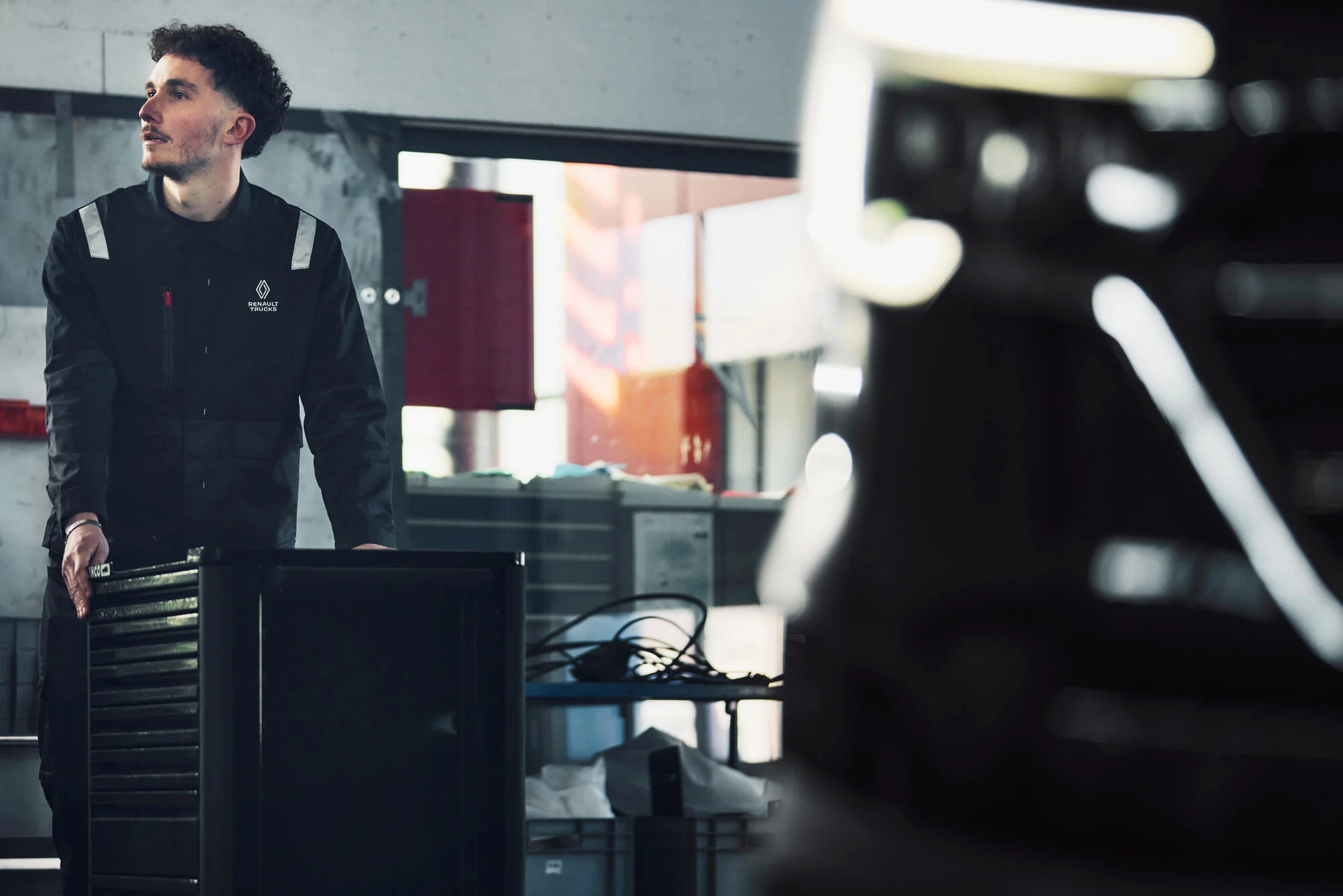 Mécanicien avec une servante, s'apretant à faire l'entretien d'un utilitaire (Trafic Renault Trucks)